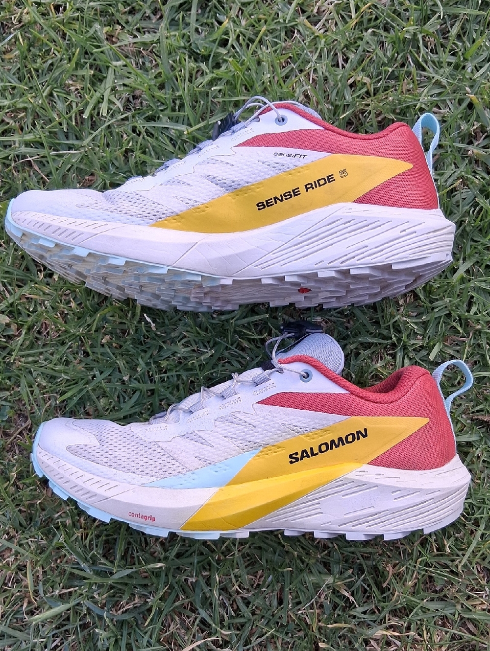 Salomon trail shoes in white, yellow, coral with light blue accents
